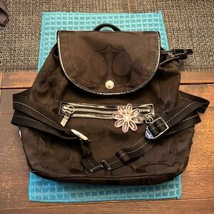 Kyra Daisy Signature Backpack
Black with pink daisy keychain